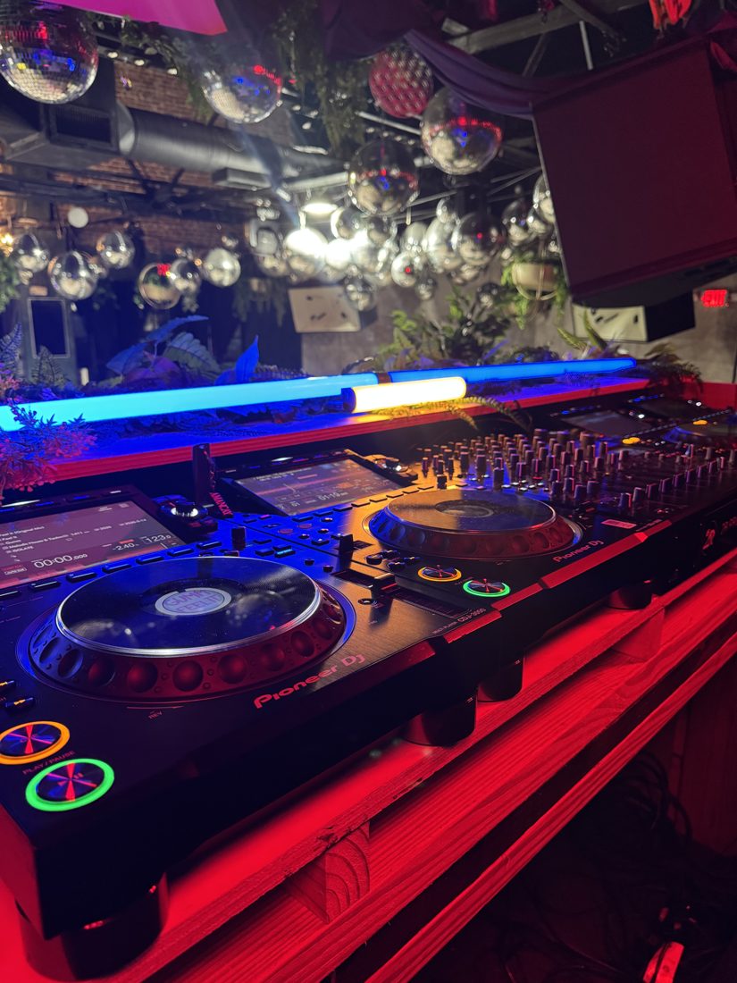 Pioneer DJ setup under red and blue light with LED tubes and disco balls