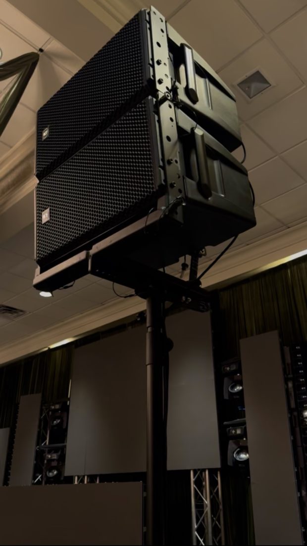 Line array speakers mounted on a pole in a ballroom