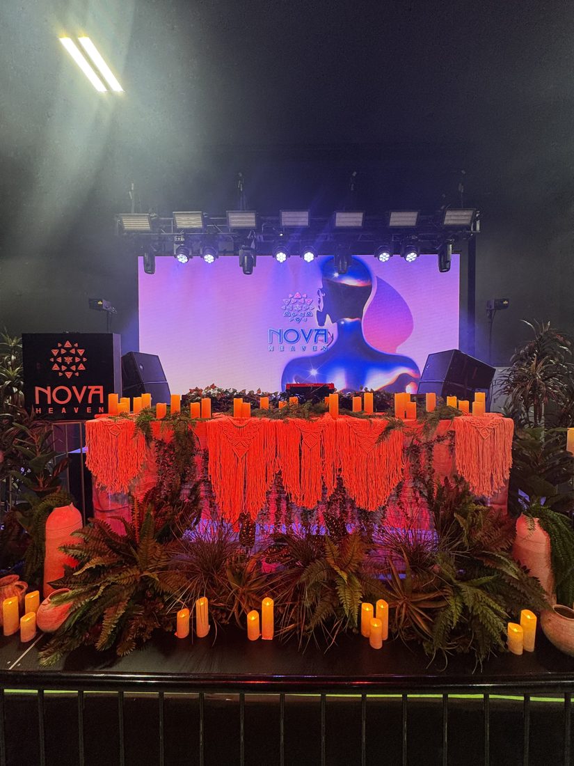 Nova Heaven DJ booth with fringe, candles and tropical plants